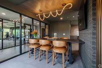 A modern dining area with a wooden table and chairs.